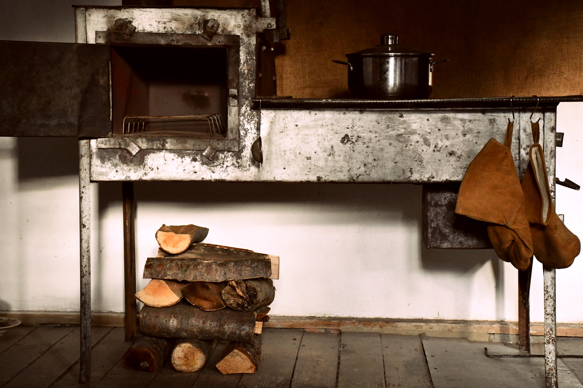 一个小厨师与木材堆放整齐beneat炉子h it.