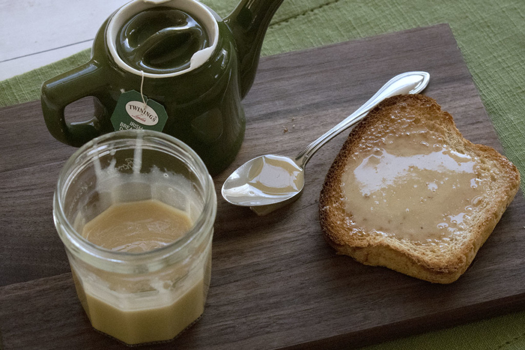 把茶放在砧板上，再放上一块涂着枫奶油的烤面包。